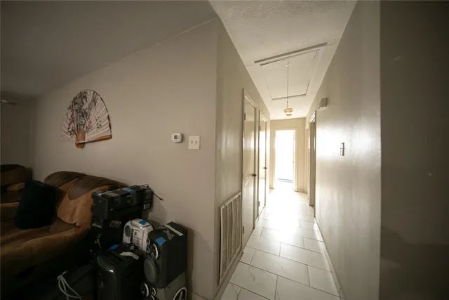 a view of a hallway to a livingroom with furniture