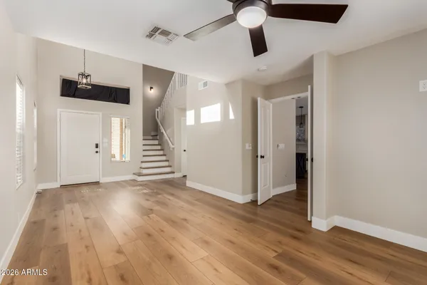 an empty room with wooden floor and entryway