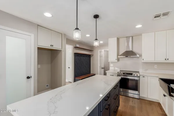 a kitchen with kitchen island a counter space a sink stainless steel appliances and cabinets