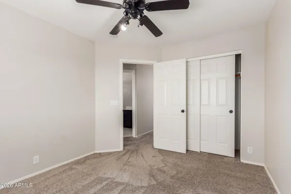a view of an empty room and chandelier fan