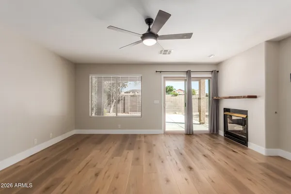 a view of empty room with wooden floor and fireplace