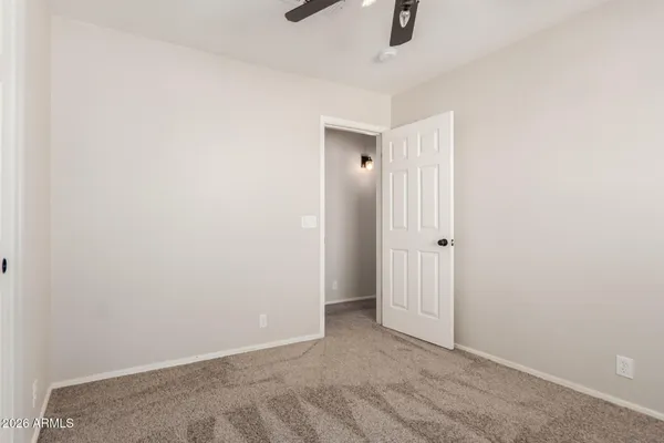 an empty room with a ceiling fan and window