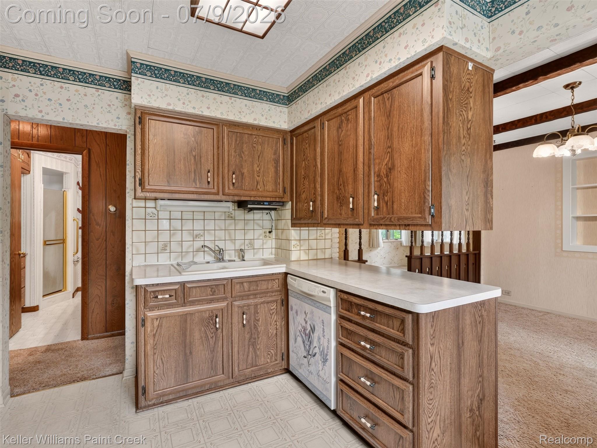 204 Russell Road Kawkawlin, MI 48631 - Photo 29 of 82 U-shaped kitchen area featuring wood-finish cabinetry, tile backsplash, laminate countertops, and a built-in sink