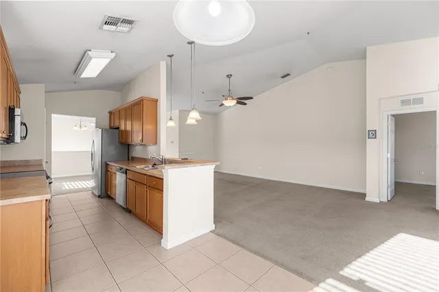 a large kitchen with stainless steel appliances kitchen island granite countertop a refrigerator and a sink
