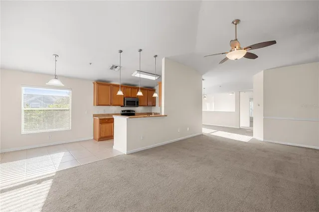 a view of a kitchen with an empty room and a window
