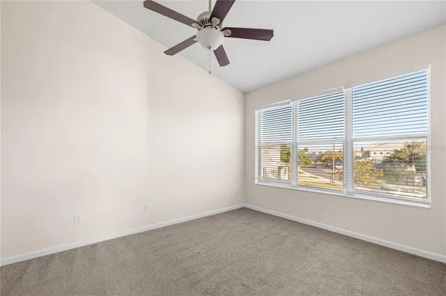 an empty room with a window and a fan