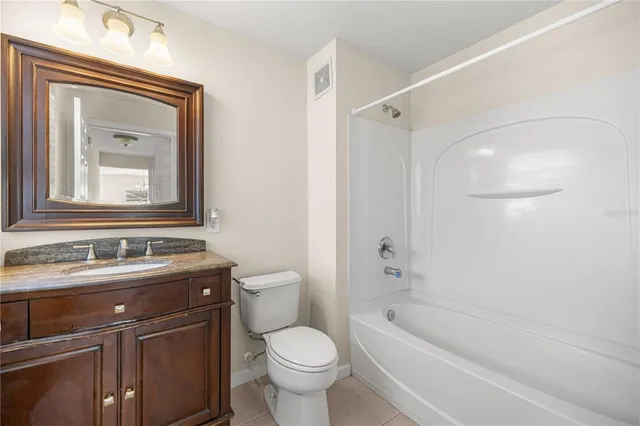 a bathroom with a bathtub shower sink mirror vanity and toilet