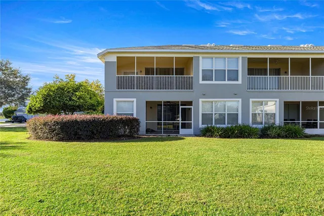 a view of a house with a yard and a large tree