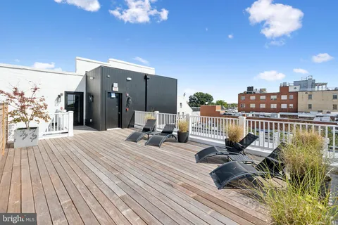 a view of a balcony with dining table and chairs