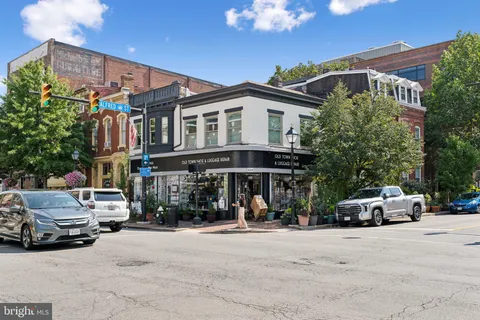 a front view of a building with cars parked