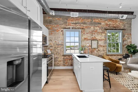 a kitchen that has a sink a stove and a refrigerator