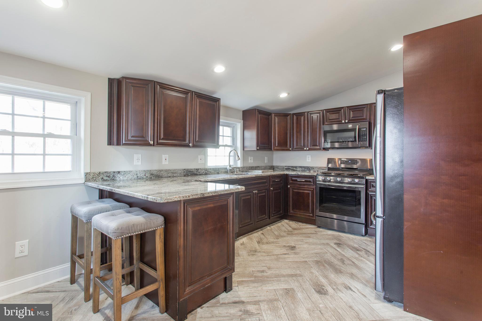 1025 Edgerton Road Secane, PA 19018 - Photo 9 of 21 a kitchen with kitchen island granite countertop wooden cabinets and a stove