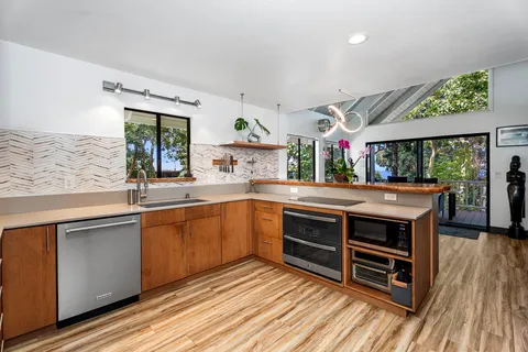 a kitchen with stainless steel appliances granite countertop a stove and a wooden floors