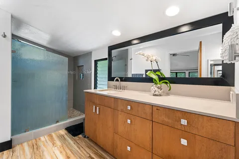 a spacious bathroom with a granite countertop sink and a mirror