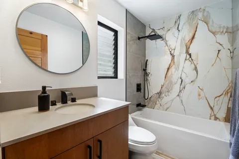 a bathroom with a sink a toilet and a mirror