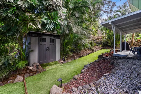 a view of a house with backyard and sitting area