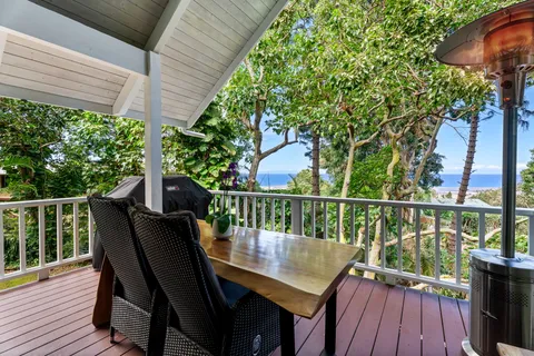 a view of a balcony with wooden floor and outdoor seating