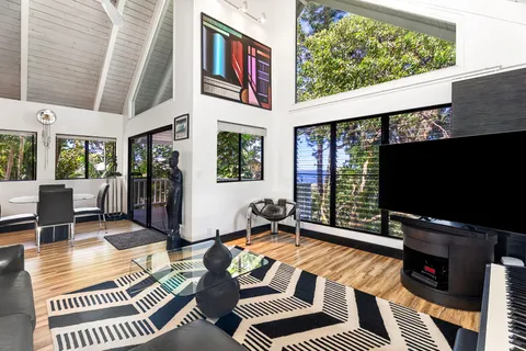 a living room with furniture a flat screen tv and a large window