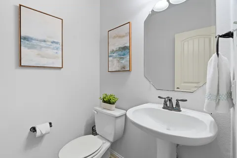 a bathroom with a toilet a sink and mirror