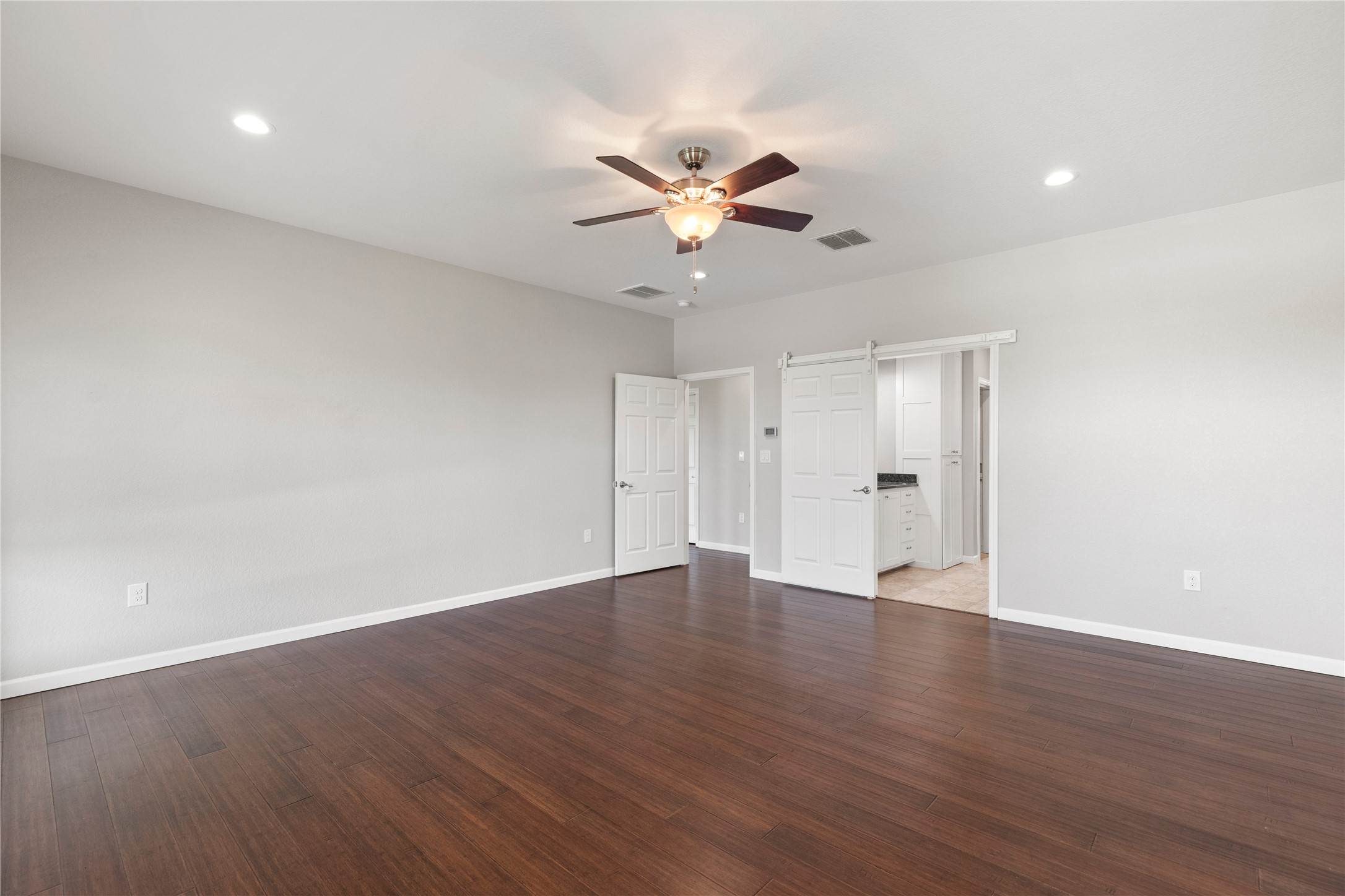 1293 Pioneer Road Seguin, TX 78155 - Photo 16 of 40 Rich hardwood floors complement neutral walls in this naturally illuminated bedroom with recessed lighting and a ceiling fan.