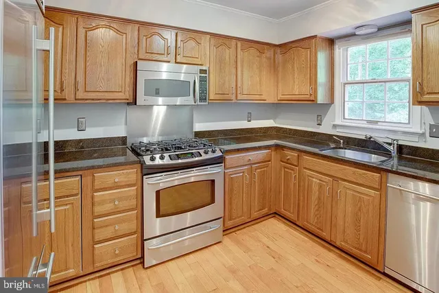 a kitchen with granite countertop cabinets stainless steel appliances and a sink