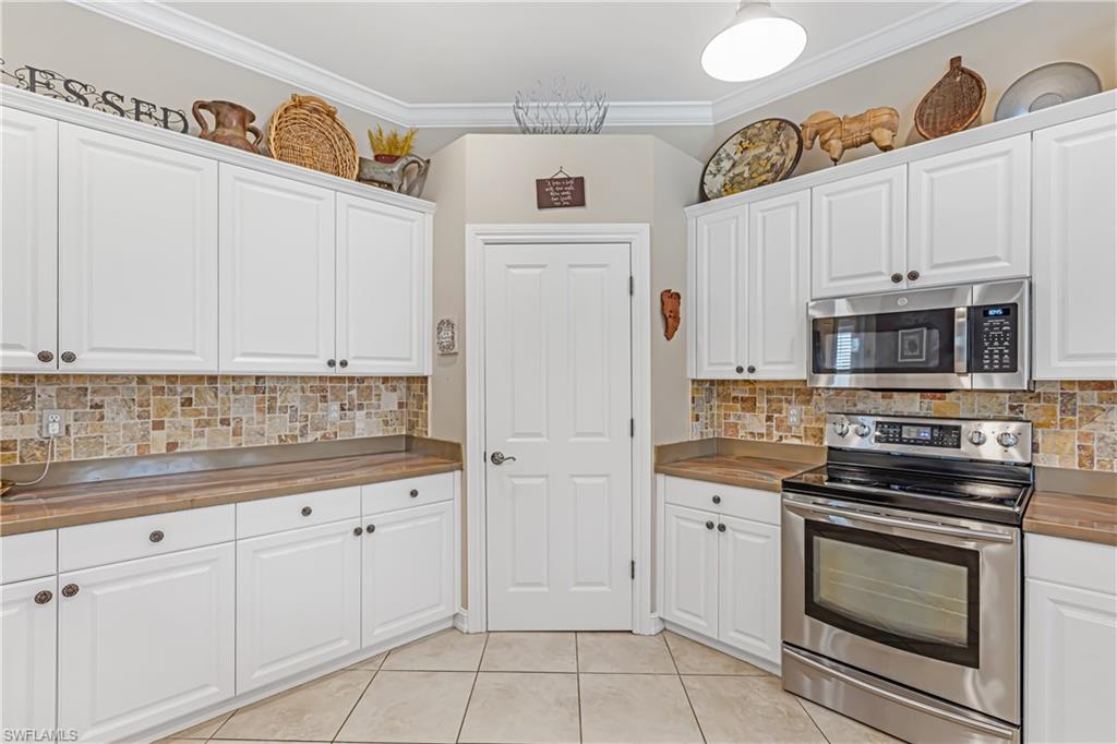 12567 Grandezza Circle Estero, FL 33928 - Photo 14 of 47 a kitchen with granite countertop white cabinets and stainless steel appliances