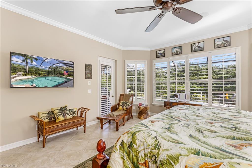 12567 Grandezza Circle Estero, FL 33928 - Photo 17 of 47 a spacious bedroom with a bed a couch and a chandelier