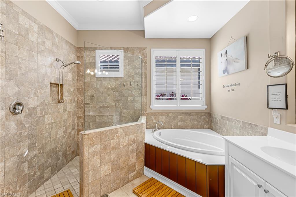 12567 Grandezza Circle Estero, FL 33928 - Photo 18 of 47 a bathroom with a granite countertop sink a mirror a bathtub and shower