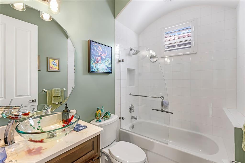 12567 Grandezza Circle Estero, FL 33928 - Photo 22 of 47 a bathroom with a granite countertop sink mirror vanity and toilet