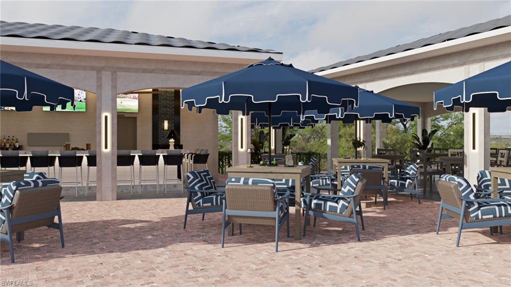 12567 Grandezza Circle Estero, FL 33928 - Photo 46 of 47 a view of a patio with dining table and chairs under an umbrella