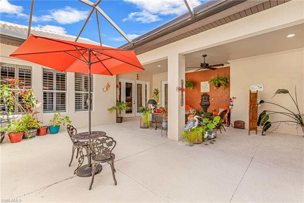 12567 Grandezza Circle Estero, FL 33928 - Photo 5 of 47 a patio with a table and chairs under an umbrella