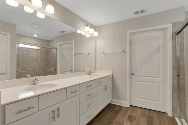 a bathroom with double vanity sink and a mirror