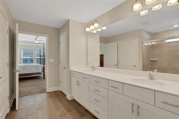 a en suite bathroom with double sink a toilet a shower and a mirror