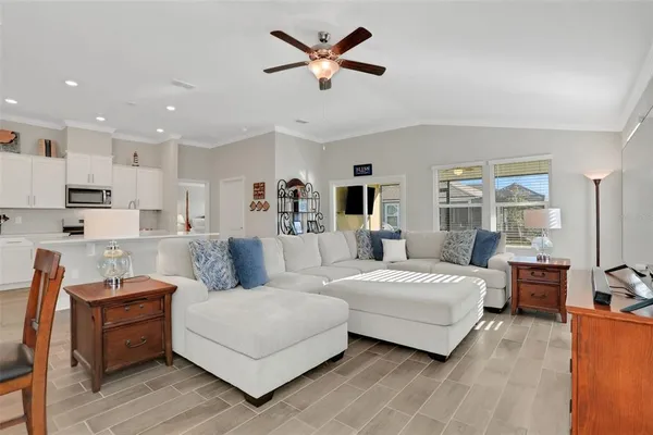 a living room with furniture and view of kitchen
