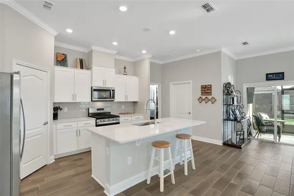 a kitchen with white cabinets and stainless steel appliances