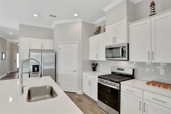 a kitchen with stainless steel appliances granite countertop a sink stove and refrigerator