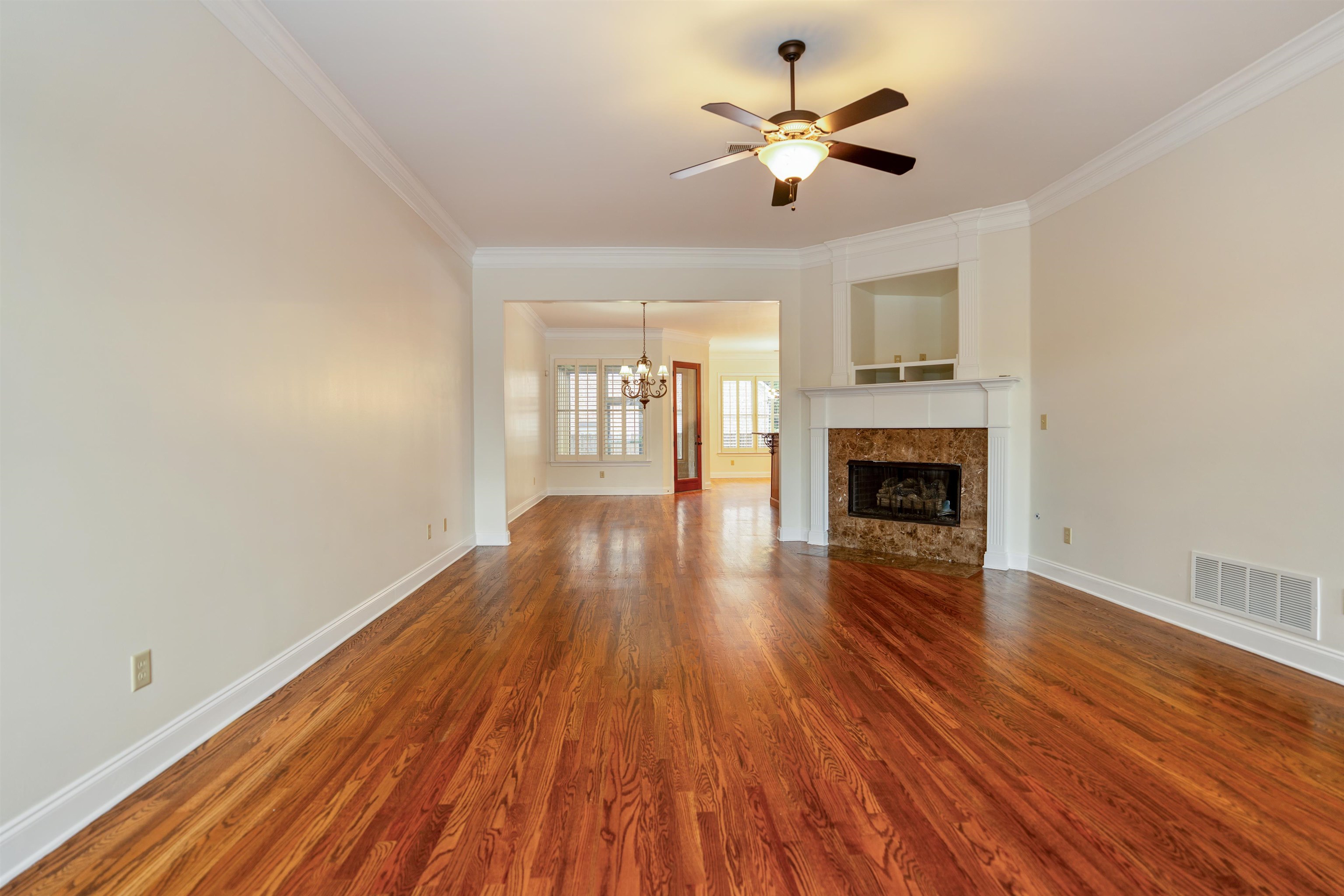 3485 East Taplow Way Collierville, TN 38017 - Photo 3 of 38 a view of empty room with wooden floor and fireplace