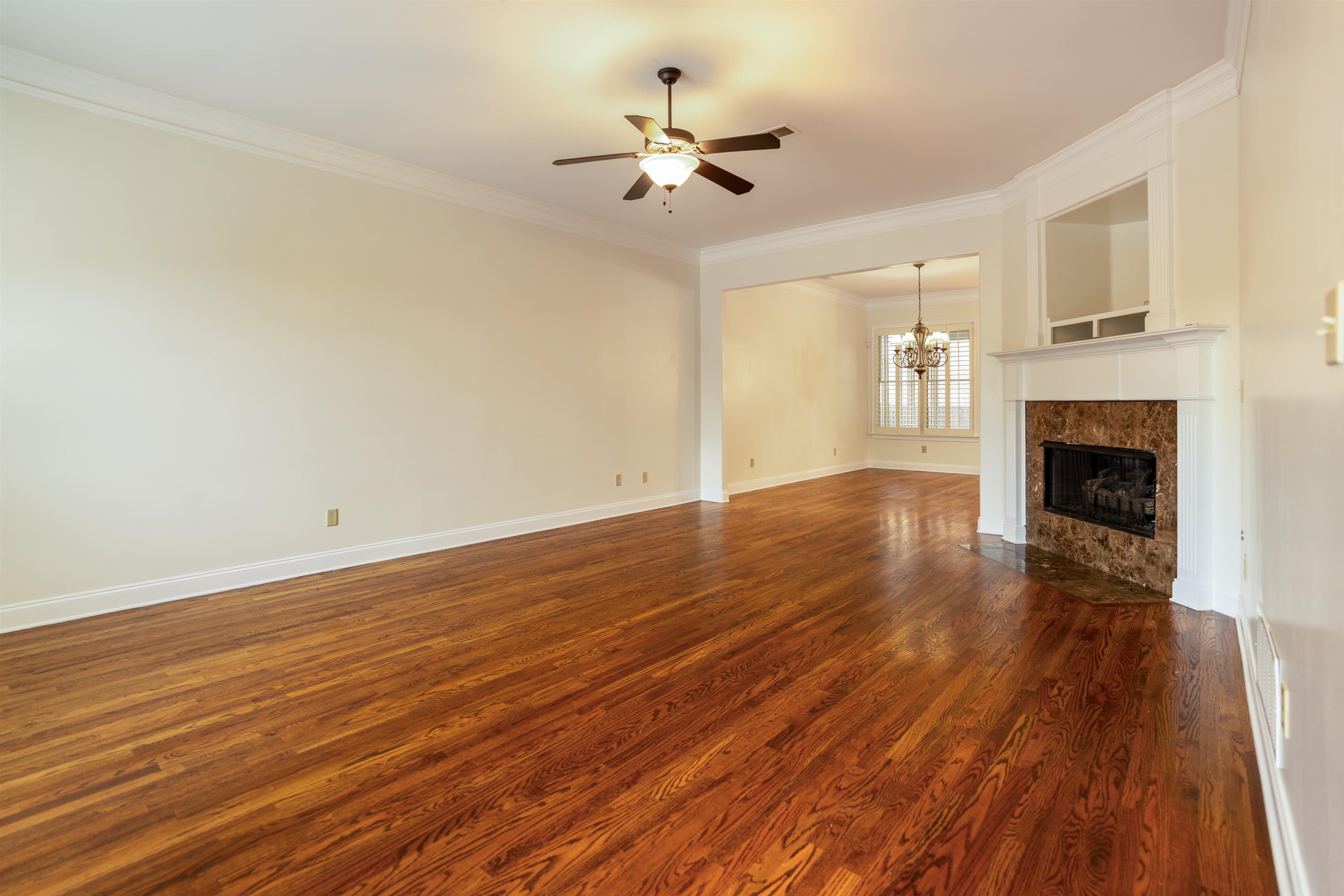 3485 East Taplow Way Collierville, TN 38017 - Photo 4 of 38 a view of an empty room with wooden floor and a fireplace