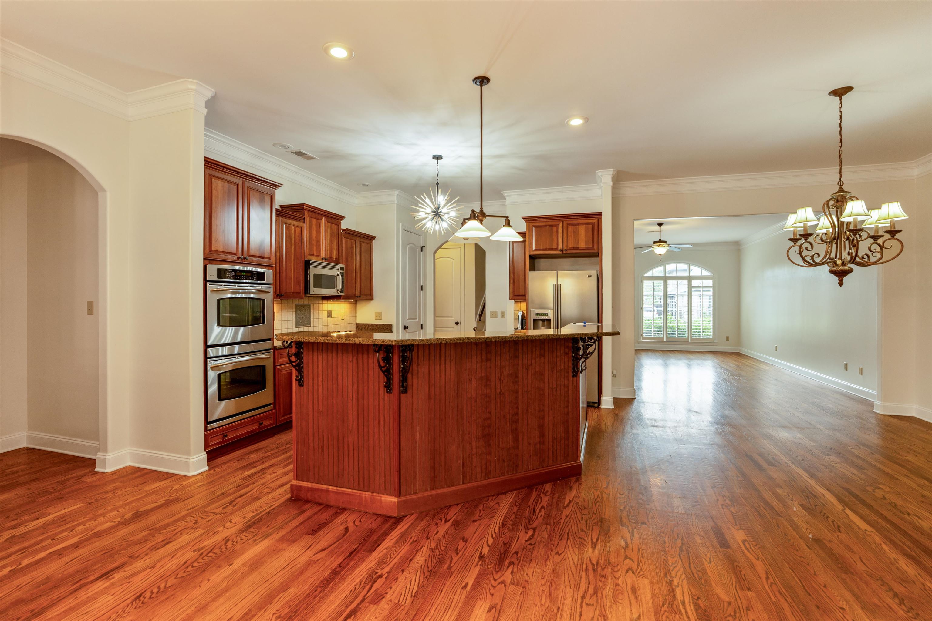3485 East Taplow Way Collierville, TN 38017 - Photo 6 of 38 Kitchen featuring stainless steel appliances, dark stone counters, dark wood-style floors, a kitchen breakfast bar, and recessed lighting