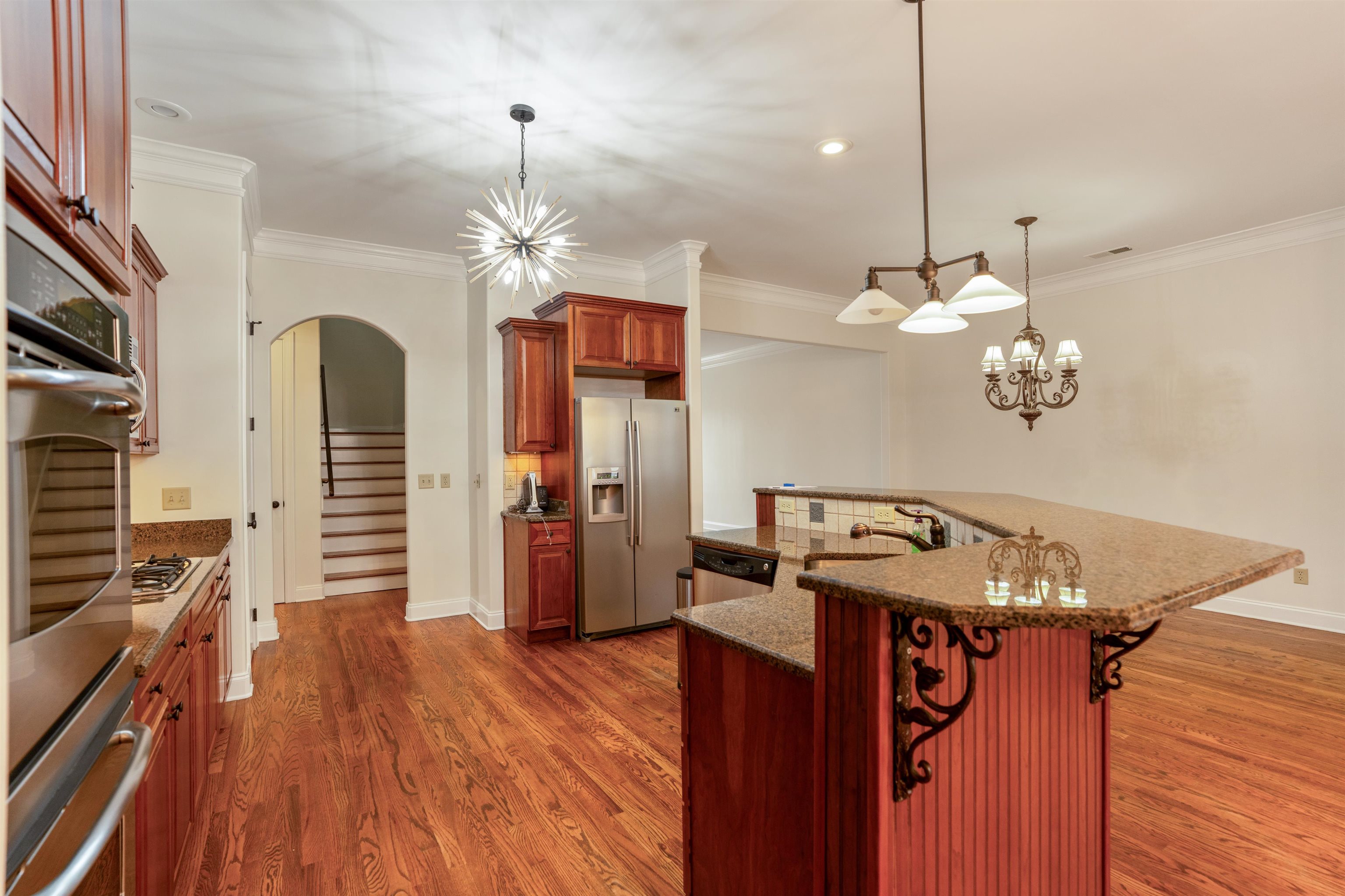 3485 East Taplow Way Collierville, TN 38017 - Photo 7 of 38 a kitchen with stainless steel appliances granite countertop a refrigerator a oven and a wooden floor