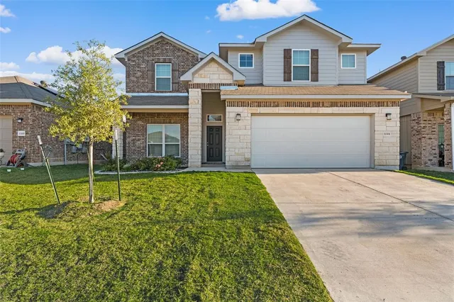 a view of a white house with a small yard and large tree