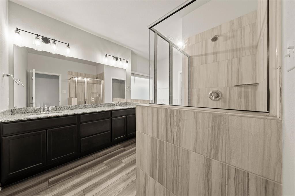 11304 Solar Street Lorena, TX 76655 - Photo 15 of 34 Bathroom featuring a shower stall, double vanity, and wood tiled floors