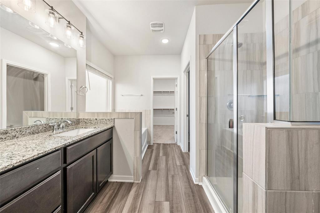 11304 Solar Street Lorena, TX 76655 - Photo 18 of 34 Bathroom featuring a walk in closet, vanity, a shower stall, dark wood-style floors, and recessed lighting