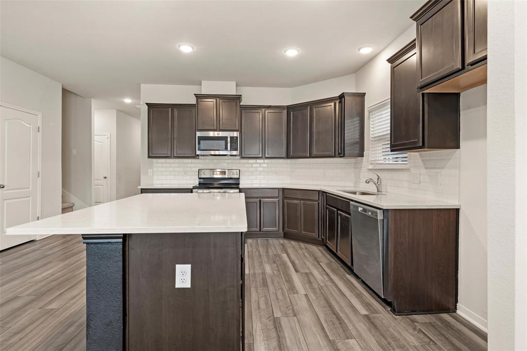 11304 Solar Street Lorena, TX 76655 - Photo 7 of 34 Kitchen featuring dark brown cabinets, stainless steel appliances, light stone counters, tasteful backsplash, and recessed lighting