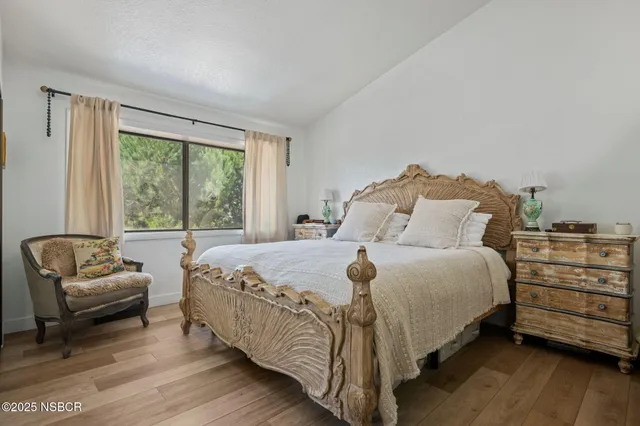 a bed sitting in a bedroom next to a window with balcony
