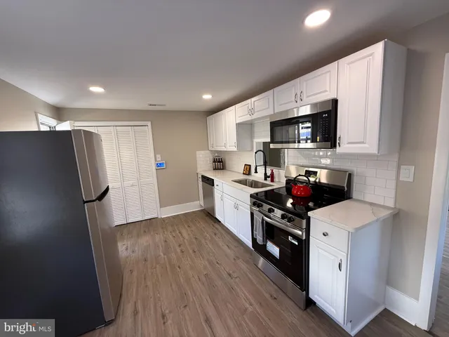 a metallic refrigerator freezer sitting in a kitchen