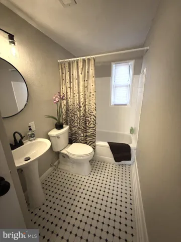 a bathroom with a toilet and a shower curtain