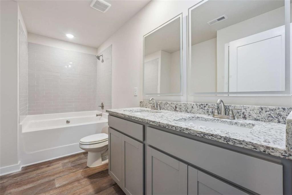 4811 Station Lane Atlanta, GA 30349 - Photo 16 of 25 a bathroom with a granite countertop sink toilet mirror and bathtub