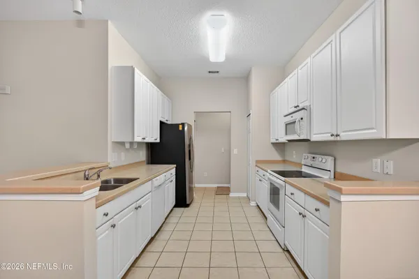 a kitchen with stainless steel appliances a refrigerator sink and cabinets