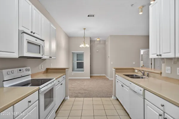 a kitchen that has a sink a stove and cabinets